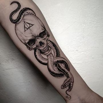 Schedel tattoo op de onderarm met slang