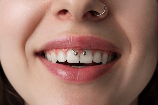 Close-up of smiley piercing and nose ring