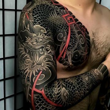 Black and grey dragon sleeve tattoo with red accents