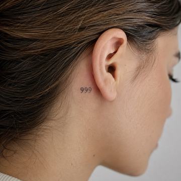 Small 999 tattoo behind the ear