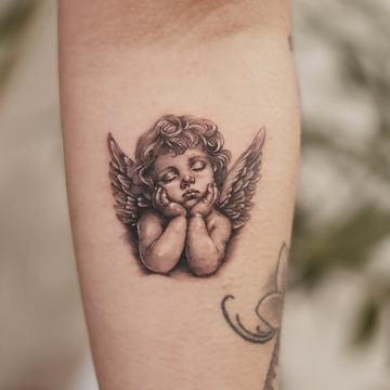 Cherub angel face tattoo with small wings