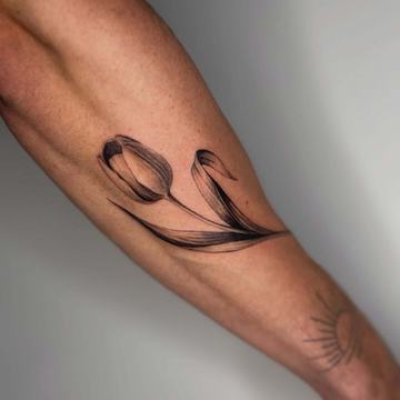 Black and grey tulip tattoo on the forearm