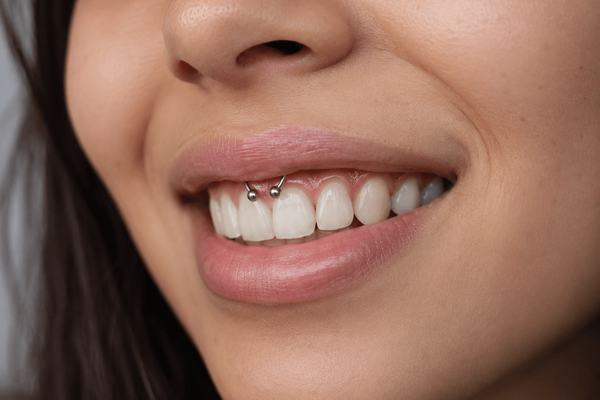 Small smiley piercing jewelry on the upper frenulum