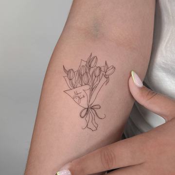 Fine line tulip tattoo with small bouquet detail