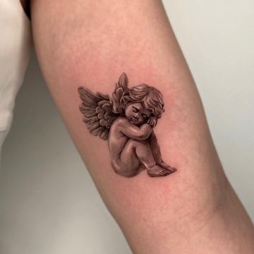 Seated cherub angel tattoo with soft shadows