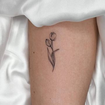 Small tulip tattoo on the leg