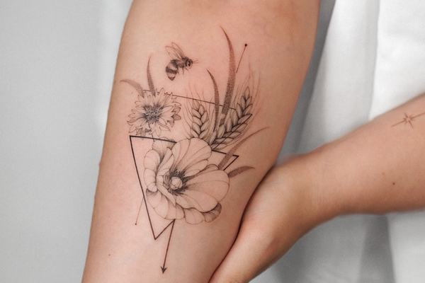 Fine line triangle tattoo with flowers and arrow