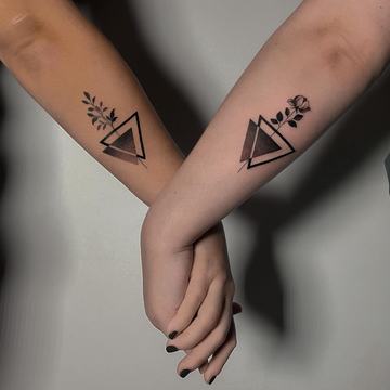 Matching triangle tattoos with small botanical details