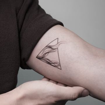 Fine line triangle tattoo with soft abstract shading